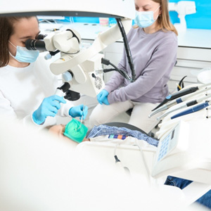Dentist performing pulp therapy on child