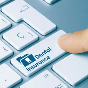 Person clicking keyboard button reading dental insurance