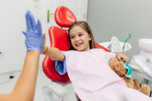 a young girl high-fiving her dentist