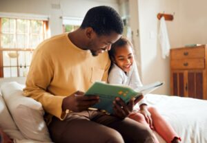 Dad and daughter reading a book together